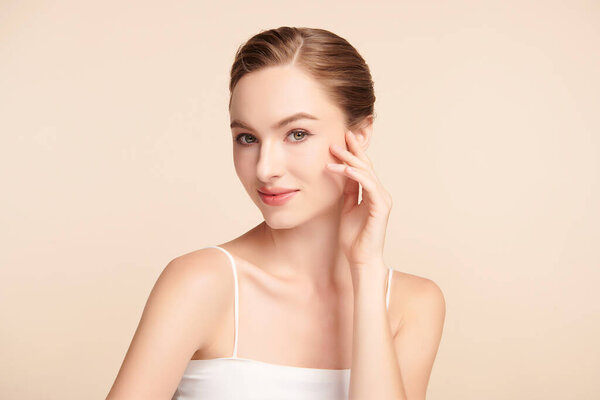 Beautiful young woman with clean fresh skin on beige background, Face care, Facial treatment, Cosmetology, beauty and spa, women portrait.