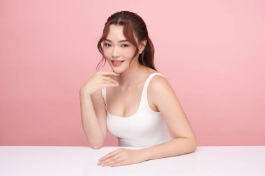 Pembe arka planda temiz tenli güzel Asyalı kadın, yüz bakımı, yüz bakımı, kozmetoloji, güzellik ve kaplıca, Asyalı kadın portresi.