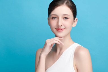 Mavi arka planda taze cildi temiz genç bir kadın, yüz bakımı, yüz bakımı, kozmetoloji, güzellik ve kaplıca, kadın portresi.