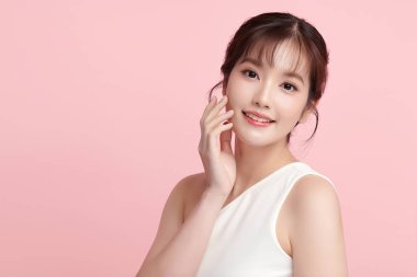Pembe arka planda temiz tenli güzel Asyalı kadın, yüz bakımı, yüz bakımı, kozmetoloji, güzellik ve kaplıca, Asyalı kadın portresi.