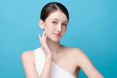 Mavi arka planda taze cildi temiz genç bir kadın, yüz bakımı, yüz bakımı, kozmetoloji, güzellik ve kaplıca, kadın portresi.