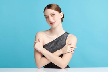 Mavi arka planda taze cildi temiz genç bir kadın, yüz bakımı, yüz bakımı, kozmetoloji, güzellik ve kaplıca, kadın portresi.