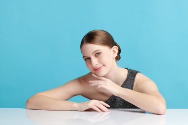 Mavi arka planda taze cildi temiz genç bir kadın, yüz bakımı, yüz bakımı, kozmetoloji, güzellik ve kaplıca, kadın portresi.