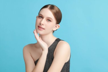 Mavi arka planda taze cildi temiz genç bir kadın, yüz bakımı, yüz bakımı, kozmetoloji, güzellik ve kaplıca, kadın portresi.