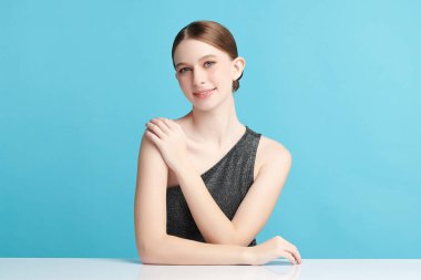 Mavi arka planda taze cildi temiz genç bir kadın, yüz bakımı, yüz bakımı, kozmetoloji, güzellik ve kaplıca, kadın portresi.