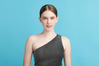 Mavi arka planda taze cildi temiz genç bir kadın, yüz bakımı, yüz bakımı, kozmetoloji, güzellik ve kaplıca, kadın portresi.