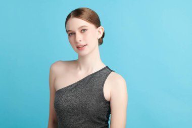 Mavi arka planda taze cildi temiz genç bir kadın, yüz bakımı, yüz bakımı, kozmetoloji, güzellik ve kaplıca, kadın portresi.