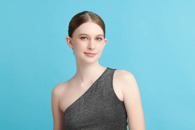 Mavi arka planda taze cildi temiz genç bir kadın, yüz bakımı, yüz bakımı, kozmetoloji, güzellik ve kaplıca, kadın portresi.