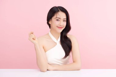 Pembe arka planda, temiz ve taze bir teni olan güzel bir Asyalı kadın. Cilt bakımı, yüz bakımı, kozmetoloji, güzellik ve kaplıca. Asyalı bir kadının zarif bir portresi..