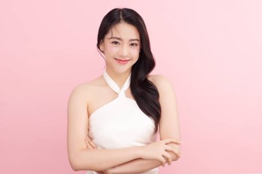 Pembe arka planda, temiz ve taze bir teni olan güzel bir Asyalı kadın. Cilt bakımı, yüz bakımı, kozmetoloji, güzellik ve kaplıca. Asyalı bir kadının zarif bir portresi..