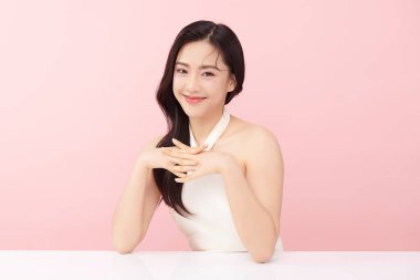 Pembe arka planda, temiz ve taze bir teni olan güzel bir Asyalı kadın. Cilt bakımı, yüz bakımı, kozmetoloji, güzellik ve kaplıca. Asyalı bir kadının zarif bir portresi..