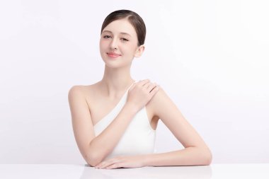 Beyaz bir arka planda temiz, taze bir teni olan güzel bir genç kadın. Cilt bakımı, yüz bakımı, kozmetoloji, güzellik ve kaplıca. Bir kadının zarif bir portresi..