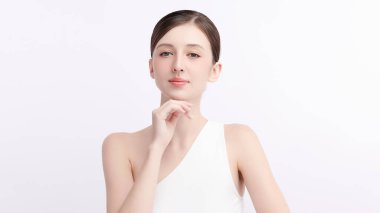 Beyaz bir arka planda temiz, taze bir teni olan güzel bir genç kadın. Cilt bakımı, yüz bakımı, kozmetoloji, güzellik ve kaplıca. Bir kadının zarif bir portresi..