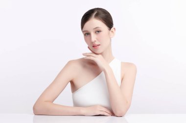 Beyaz bir arka planda temiz, taze bir teni olan güzel bir genç kadın. Cilt bakımı, yüz bakımı, kozmetoloji, güzellik ve kaplıca. Bir kadının zarif bir portresi..