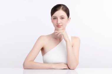 Beyaz bir arka planda temiz, taze bir teni olan güzel bir genç kadın. Cilt bakımı, yüz bakımı, kozmetoloji, güzellik ve kaplıca. Bir kadının zarif bir portresi..