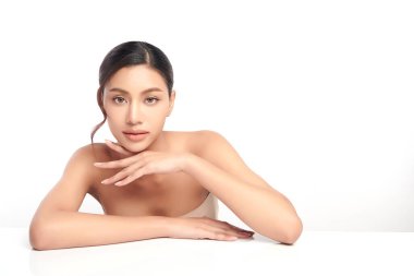 Beyaz bir arka planda, temiz ve taze bir teni olan güzel bir Asyalı kadın. Cilt bakımı, yüz bakımı, kozmetoloji, güzellik ve kaplıca. Asyalı bir kadının zarif bir portresi..