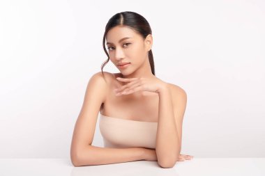 Beyaz bir arka planda, temiz ve taze bir teni olan güzel bir Asyalı kadın. Cilt bakımı, yüz bakımı, kozmetoloji, güzellik ve kaplıca. Asyalı bir kadının zarif bir portresi..