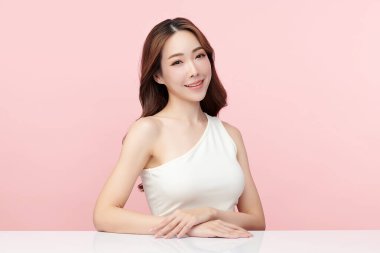 Pembe arka planda, temiz ve taze bir teni olan güzel bir Asyalı kadın. Cilt bakımı, yüz bakımı, kozmetoloji, güzellik ve kaplıca. Asyalı bir kadının zarif bir portresi..