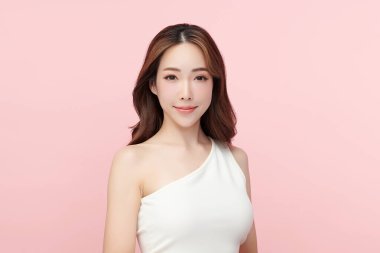 Pembe arka planda, temiz ve taze bir teni olan güzel bir Asyalı kadın. Cilt bakımı, yüz bakımı, kozmetoloji, güzellik ve kaplıca. Asyalı bir kadının zarif bir portresi..