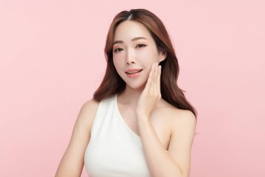Pembe arka planda, temiz ve taze bir teni olan güzel bir Asyalı kadın. Cilt bakımı, yüz bakımı, kozmetoloji, güzellik ve kaplıca. Asyalı bir kadının zarif bir portresi..