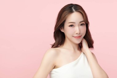 Pembe arka planda, temiz ve taze bir teni olan güzel bir Asyalı kadın. Cilt bakımı, yüz bakımı, kozmetoloji, güzellik ve kaplıca. Asyalı bir kadının zarif bir portresi..