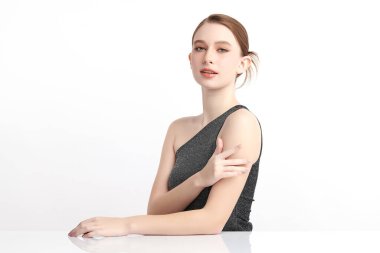 Beyaz bir arka planda temiz, taze bir teni olan güzel bir genç kadın. Cilt bakımı, yüz bakımı, kozmetoloji, güzellik ve kaplıca. Bir kadının zarif bir portresi..