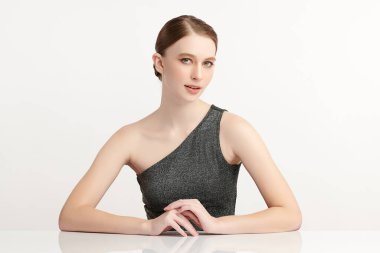 Beyaz bir arka planda temiz, taze bir teni olan güzel bir genç kadın. Cilt bakımı, yüz bakımı, kozmetoloji, güzellik ve kaplıca. Bir kadının zarif bir portresi..