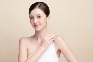 Bej bir arka planda temiz, taze bir teni olan güzel bir genç kadın. Cilt bakımı, yüz bakımı, kozmetoloji, güzellik ve kaplıca. Bir kadının zarif bir portresi..