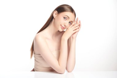 Beyaz bir arka planda temiz, taze bir teni olan güzel bir genç kadın. Cilt bakımı, yüz bakımı, kozmetoloji, güzellik ve kaplıca. Bir kadının zarif bir portresi..