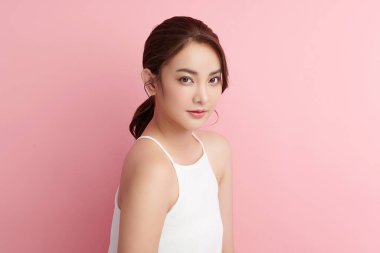 Pembe arka planda, temiz ve taze bir teni olan güzel bir Asyalı kadın. Cilt bakımı, yüz bakımı, kozmetoloji, güzellik ve kaplıca. Asyalı bir kadının zarif bir portresi..