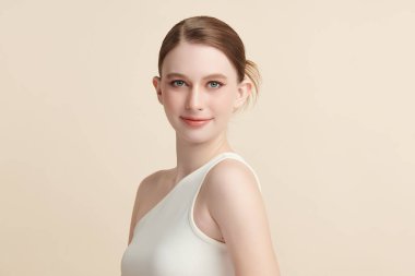 Bej bir arka planda temiz, taze bir teni olan güzel bir genç kadın. Cilt bakımı, yüz bakımı, kozmetoloji, güzellik ve kaplıca. Bir kadının zarif bir portresi..