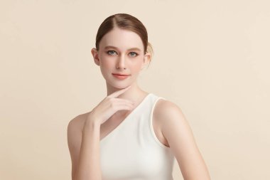 Bej bir arka planda temiz, taze bir teni olan güzel bir genç kadın. Cilt bakımı, yüz bakımı, kozmetoloji, güzellik ve kaplıca. Bir kadının zarif bir portresi..