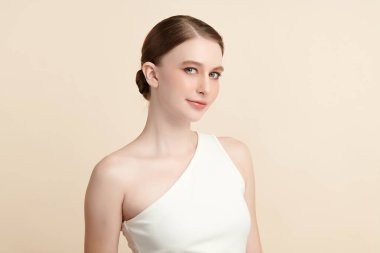 Bej bir arka planda temiz, taze bir teni olan güzel bir genç kadın. Cilt bakımı, yüz bakımı, kozmetoloji, güzellik ve kaplıca. Bir kadının zarif bir portresi..