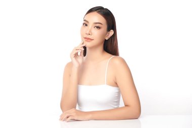 Beyaz bir arka planda, temiz ve taze bir teni olan güzel bir Asyalı kadın. Cilt bakımı, yüz bakımı, kozmetoloji, güzellik ve kaplıca. Asyalı bir kadının zarif bir portresi..