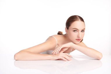 Beyaz bir arka planda temiz, taze bir teni olan güzel bir genç kadın. Cilt bakımı, yüz bakımı, kozmetoloji, güzellik ve kaplıca. Bir kadının zarif bir portresi..