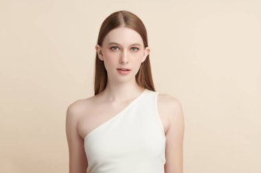 Bej bir arka planda temiz, taze bir teni olan güzel bir genç kadın. Cilt bakımı, yüz bakımı, kozmetoloji, güzellik ve kaplıca. Bir kadının zarif bir portresi..