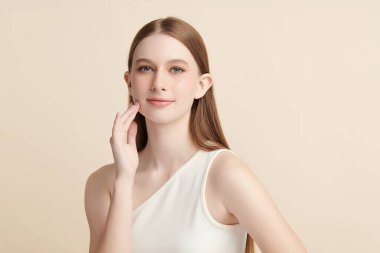 Bej bir arka planda temiz, taze bir teni olan güzel bir genç kadın. Cilt bakımı, yüz bakımı, kozmetoloji, güzellik ve kaplıca. Bir kadının zarif bir portresi..