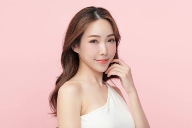 Pembe arka planda, temiz ve taze bir teni olan güzel bir Asyalı kadın. Cilt bakımı, yüz bakımı, kozmetoloji, güzellik ve kaplıca. Asyalı bir kadının zarif bir portresi..