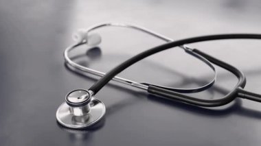 Koyu mavi arka planda tıbbi steteskop. Mavi bir yüzey üzerinde dinlenen steteskopun yakın çekimi, karmaşık tasarımı ve sağlık ve tıpla olan ilişkisini gözler önüne seriyor. 3d canlandırma canlandırması