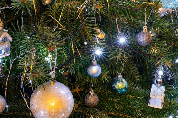 Bir Noel ağacının yakını. Mücevherlerle süslenmiş ve ışık yıldızlarıyla süslenmiş.