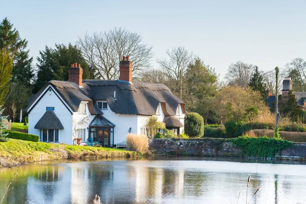 Beautiful chocolate-box thatched cottage and pond in the Shropshire village of Badger in the UK