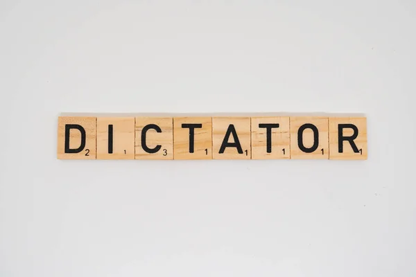stock image Wooden title spelling the word dictator isolated on a white background