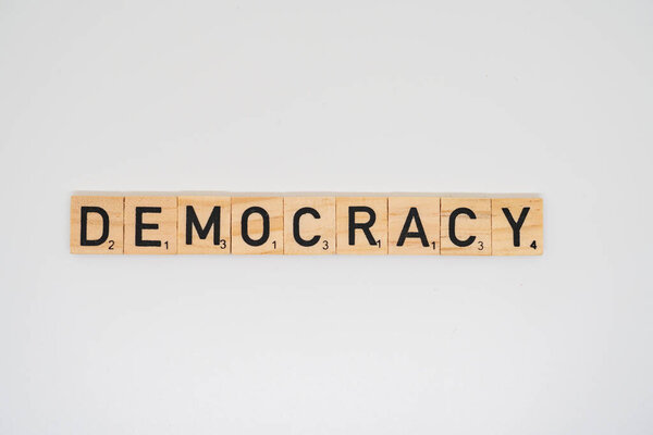 Wooden title spelling the word democracy isolated on a white background