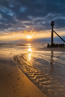 Kuzey Norfolk, İngiltere 'deki Mundesley sahilinde doğan güneşin portresi.