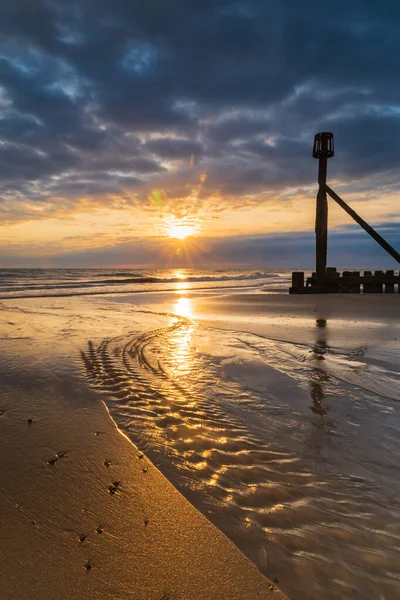 Kuzey Norfolk, İngiltere 'deki Mundesley sahilinde doğan güneşin portresi.