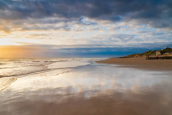 Gündoğumunda Kuzey Norfolk İngiltere, Mundesley 'deki boş bir sahilde gelgit azalıyor.