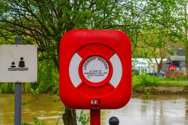 Red and white lifebuoy on the banks of the River Severn in Bridgnorth, Shropshire, UK clipart