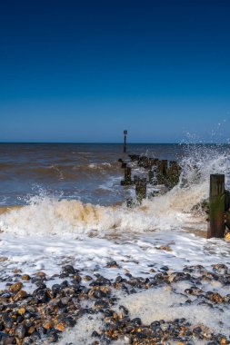 Dalgalar Trimingham, North Norfolk, İngiltere 'de bir ahşap dağa çarpıyor.