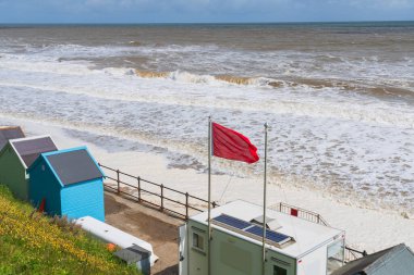 Mundesley, Kuzey Norfolk 'taki sahilde kırmızı bayrak dalgalı denizleri ve tehlikeyi gösteriyor
