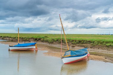 Colourful boats on the River Glaven in Blakeney, North Norfolk, UK clipart